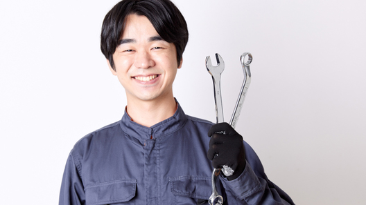[alt=笑顔の自動車整備士。]