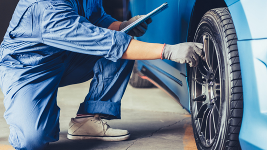 タイヤの点検をする自動車整備士の姿。